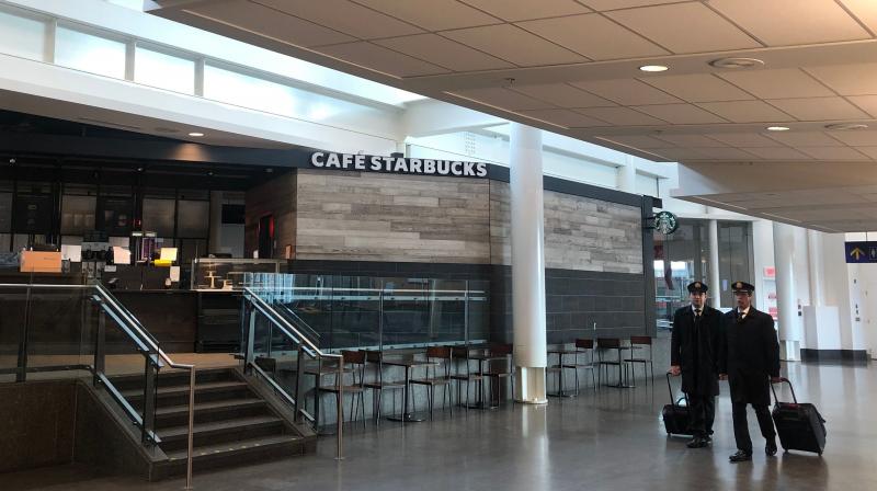 An air crew walks past an empty Starbucks at Montreal-Pierre Elliott Trudeau International Airport in Montreal, Canada. AFP Photo