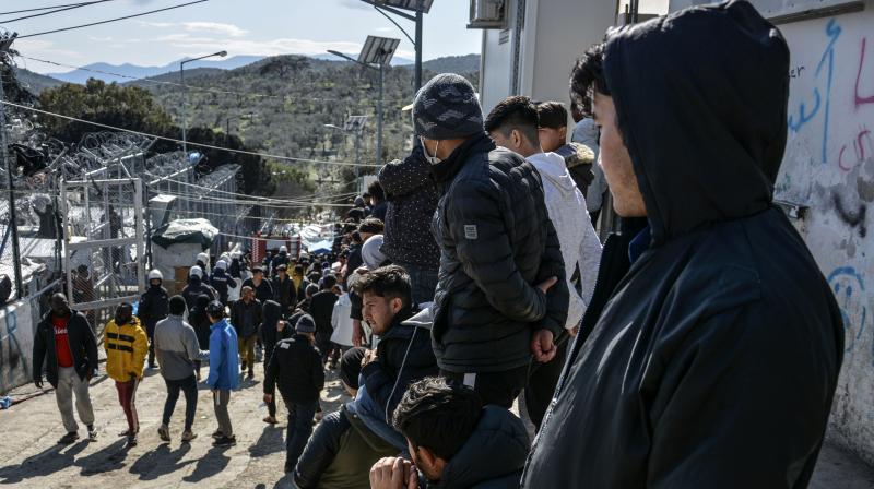 Migrants gather as riot police guard a gate in Moria refugee camp on the northeastern Aegean island of Lesbos, Greece. AP Photo Migrants gather as riot police guard a gate in Moria refugee camp on the northeastern Aegean island of Lesbos, Greece. AP Photo
