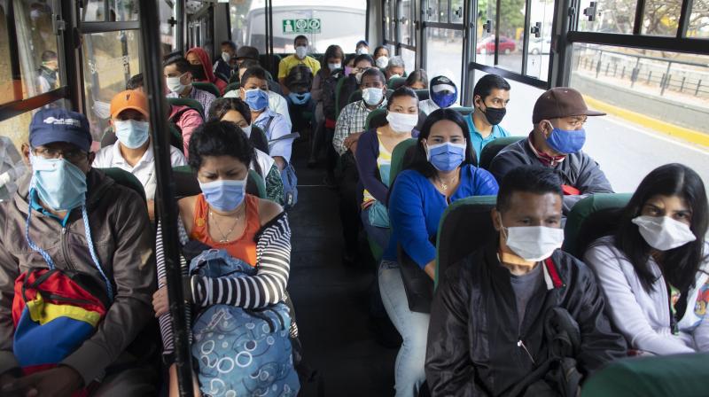 People wearing protective masks as a precaution against the spread of the new coronavirus travel on a bus in Caracas, Venezuela. AP Photo People wearing protective masks as a precaution against the spread of the new coronavirus travel on a bus in Caracas, Venezuela. AP Photo