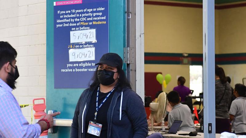 A sign posted on a door at the Obregon Park Covid-19 vaccine site reminds people to get their booster shots as children age 5-11 receive their first dose at the facility on November 4, 2021 in Los Angeles, California. ( Frederic J. BROWN / AFP)