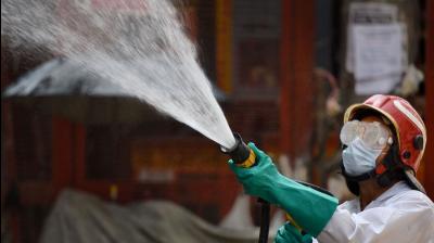 A firefighter sprays disinfectant to curb the spread of coronavirus in New Delhi. PTI Photo