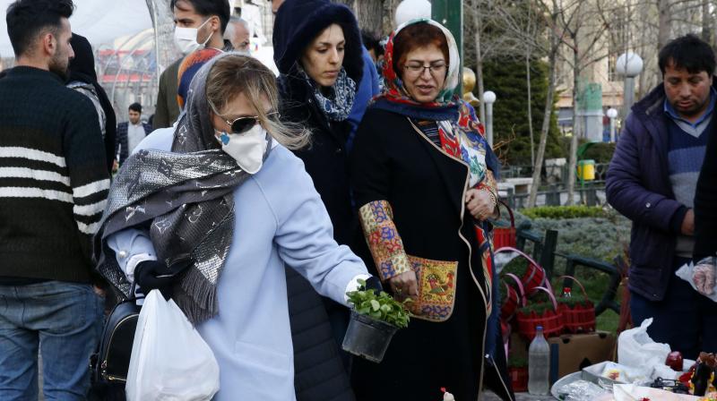 An Iranian woman wearing a protective face mask chooses traditional items ahead of Nowruz, the national New Year 2-week celebration, at the Tajrish Bazaar in the capital Tehran. AFP Photo