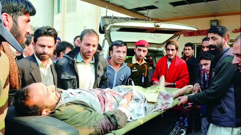People carry an injured person to a local hospital in PoK capital Muzaffarabad on Wednesday. (Photo: AP) People carry an injured person to a local hospital in PoK capital Muzaffarabad on Wednesday. (Photo: AP)