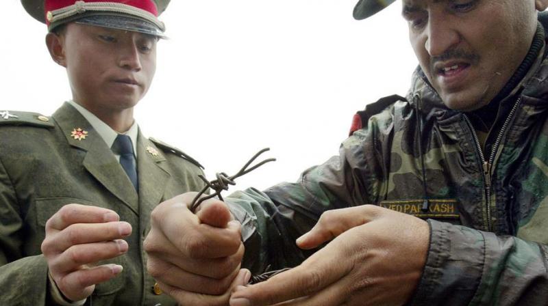 This file photo taken on July 5, 2006 shows a Chinese soldier (L) and Indian soldier placing a barbed wire fence following a meeting of military representatives at the Nathu La border crossing. (Photo: AFP) This file photo taken on July 5, 2006 shows a Chinese soldier (L) and Indian soldier placing a barbed wire fence following a meeting of military representatives at the Nathu La border crossing. (Photo: AFP)