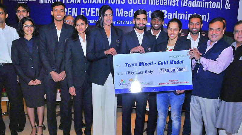 Members of the Indian badminton contingent at the Commonwealth Games in Gold Coast are all smiles while being presented a cheque for `50 lakhs by Badminton Association of India president Himanta Biswa Sarma in New Delhi on Saturday night. Members of the Indian badminton contingent at the Commonwealth Games in Gold Coast are all smiles while being presented a cheque for `50 lakhs by Badminton Association of India president Himanta Biswa Sarma in New Delhi on Saturday night.
