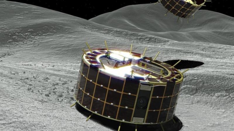 This computer image provided by the Japan Aerospace Exploration Agency (JAXA) shows two drum-shaped and solar-powered Minerva-II-1 rovers on an asteroid. JAXA said confirmation of the rovers’ touchdown has to wait until it receives data from them. (JAXA via AP) This computer image provided by the Japan Aerospace Exploration Agency (JAXA) shows two drum-shaped and solar-powered Minerva-II-1 rovers on an asteroid. JAXA said confirmation of the rovers’ touchdown has to wait until it receives data from them. (JAXA via AP)