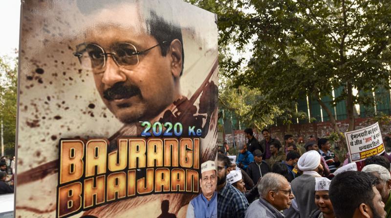 Aam Aadmi Party (AAP) supporters hold a poster of Delhi CM Arvind Kejriwal as they celebrate partys victory in the Delhi Assembly elections, at party office in New Delhi. PTI photo