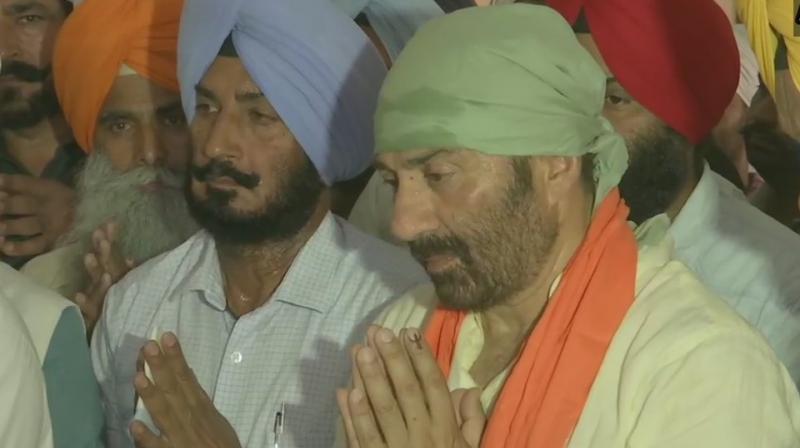 Accompanied by BJP leader Kamal Sharma, Deol offered prayers at the Gurdwara Dera Baba Nanak and had a glimpse of the Gurudwara Kartarpur Sahib in Narowal district of Pakistan through binoculars installed at 'darshan sthal' here. (Photo: ANI twitter) Accompanied by BJP leader Kamal Sharma, Deol offered prayers at the Gurdwara Dera Baba Nanak and had a glimpse of the Gurudwara Kartarpur Sahib in Narowal district of Pakistan through binoculars installed at 'darshan sthal' here. (Photo: ANI twitter)
