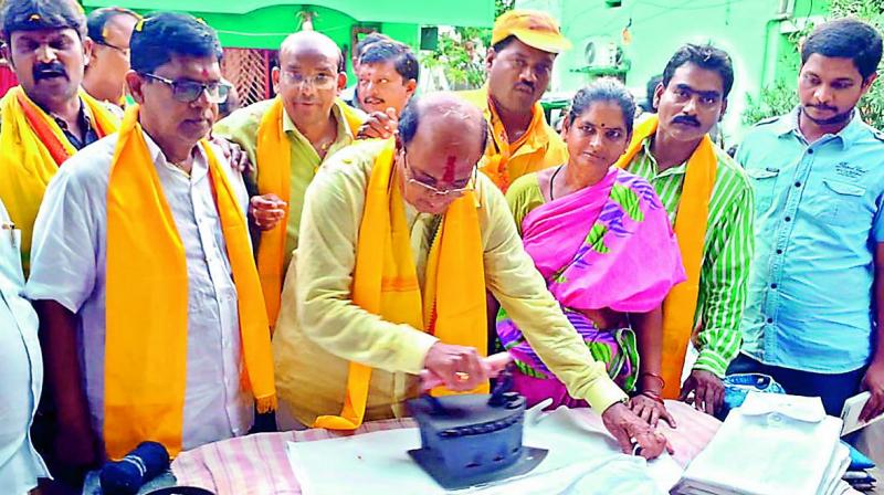 TD Rajahmundry Rural Assembly segment nominee Butchaiah Choudhary tries to iron a shirt during electioneering in Rajahmundry on Thursday. — (DC) TD Rajahmundry Rural Assembly segment nominee Butchaiah Choudhary tries to iron a shirt during electioneering in Rajahmundry on Thursday. — (DC)
