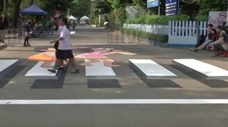 The zebra crossing outside the main entrance to Wat Bueng Thong Lang school on the outskirts of Bangkok, was painted by students and volunteers. (Photo: Screengrab)