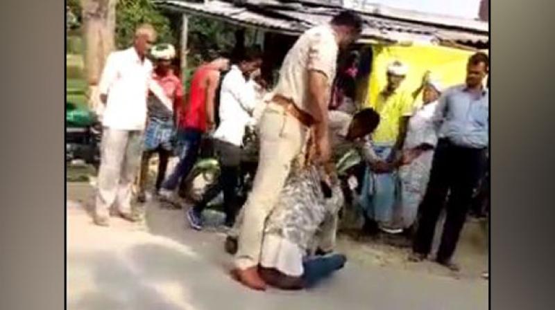 The video which was recorded by a bystander shows sub inspector Virendra Mishra and head constable Mahendra Prasad beating him up and verbally abusing him. (Photo: ANI) The video which was recorded by a bystander shows sub inspector Virendra Mishra and head constable Mahendra Prasad beating him up and verbally abusing him. (Photo: ANI)