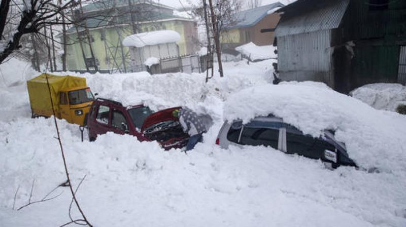 A man checks his vehicle stuck in snow in Tangmarg, northwest of Srinagar (Photo: PTI) A man checks his vehicle stuck in snow in Tangmarg, northwest of Srinagar (Photo: PTI)