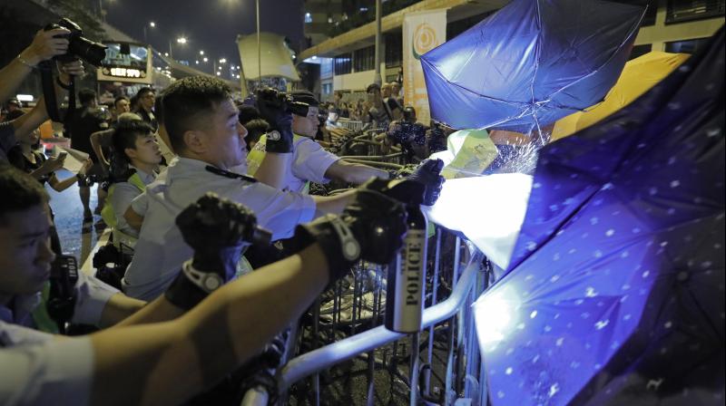 Protesters use umbrellas to block the pepper spray from police officers after clashing outside the Chinese central government's liaison office as thousands of people march in a Hong Kong on Sunday. (Photo: AP) Protesters use umbrellas to block the pepper spray from police officers after clashing outside the Chinese central government's liaison office as thousands of people march in a Hong Kong on Sunday. (Photo: AP)