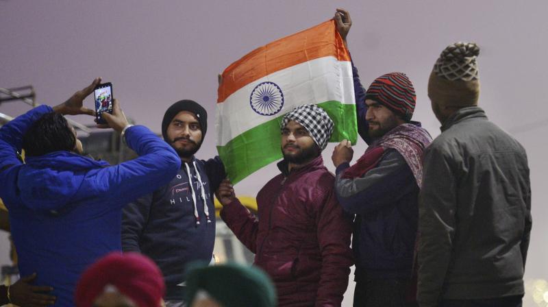 A farmer holds the Tricolor during their ongoing agitation against Centres farm reform laws, on the eve of Republic Day, in New Delhi, Monday, Jan. 25, 2021. (PTI /Ravi Choudhary)