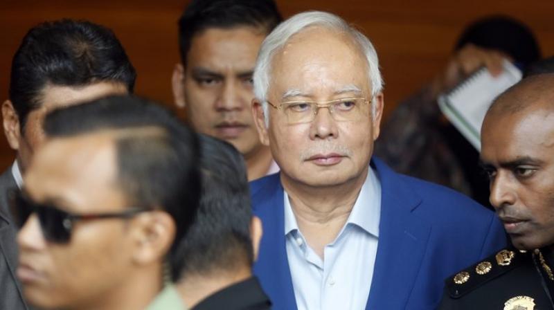 Police say he will face 21 money-laundering charges related to the mysterious transfer of huge sums into his personal bank account, a key episode in the long-running scandal. He may also face additional charges under anti-corruption laws. (Photo: AP) Police say he will face 21 money-laundering charges related to the mysterious transfer of huge sums into his personal bank account, a key episode in the long-running scandal. He may also face additional charges under anti-corruption laws. (Photo: AP)