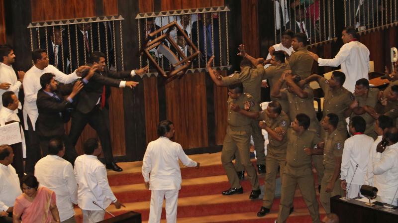 Lawmakers supporting disputed Prime Minister Rajapksa throw a chair towards police officers escorting the speaker inside parliament in Colombo, Sri Lanka, Friday, November 16, 2018. (Photo: AP) Lawmakers supporting disputed Prime Minister Rajapksa throw a chair towards police officers escorting the speaker inside parliament in Colombo, Sri Lanka, Friday, November 16, 2018. (Photo: AP)