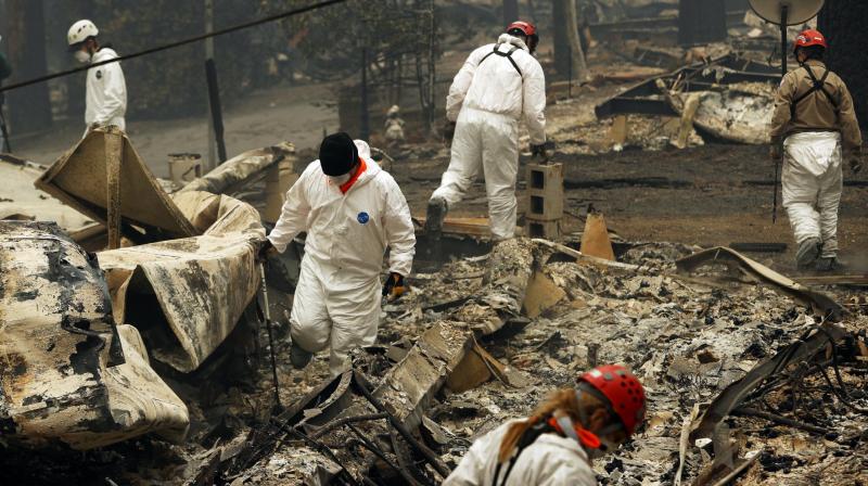 Hundreds of volunteers are sifting through ash and debris, searching for human remains before expected rains complicate their efforts. (Photo: AP) Hundreds of volunteers are sifting through ash and debris, searching for human remains before expected rains complicate their efforts. (Photo: AP)