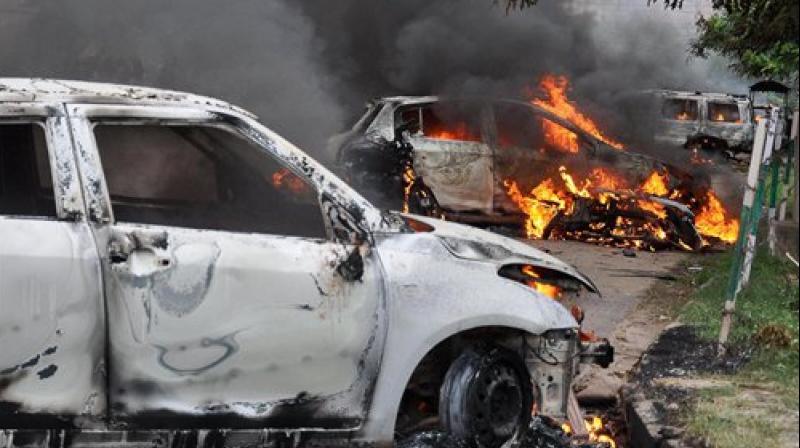 Vehicles burn in violence following Dera Sacha Sauda chief Gurmeet Ram Rahim’s conviction in Panchkula on Friday. (Photo: PTI) Vehicles burn in violence following Dera Sacha Sauda chief Gurmeet Ram Rahim’s conviction in Panchkula on Friday. (Photo: PTI)