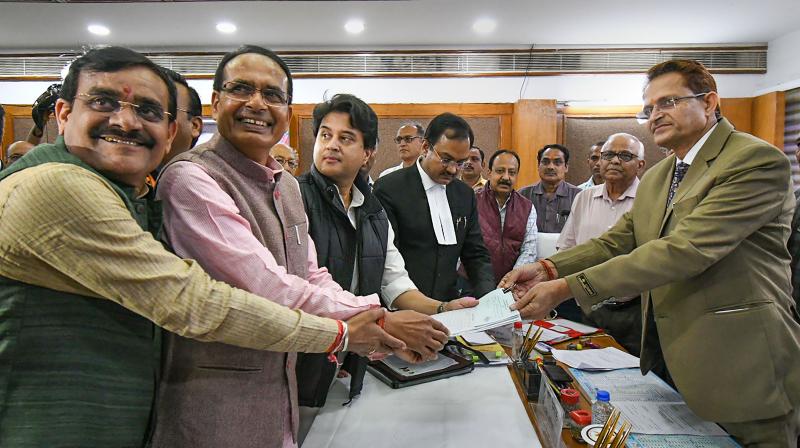Recent defector Jyotiraditya Scindia files his nomination papers for a seat in the Rajya Sabha, helped along by several hands of the BJP. (PTI) Recent defector Jyotiraditya Scindia files his nomination papers for a seat in the Rajya Sabha, helped along by several hands of the BJP. (PTI)