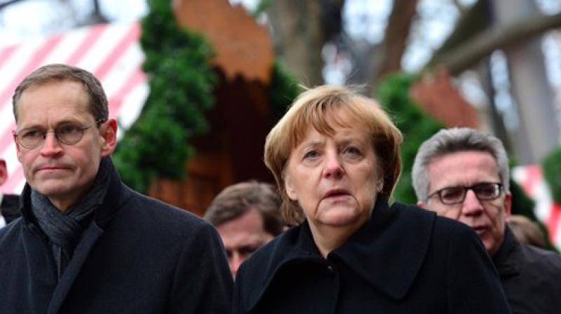 German chancellor Angela Merkel and Berlin's mayor Michael Mueller, left, arrive at the Christmas market in Berlin. (Photo: AP) German chancellor Angela Merkel and Berlin's mayor Michael Mueller, left, arrive at the Christmas market in Berlin. (Photo: AP)