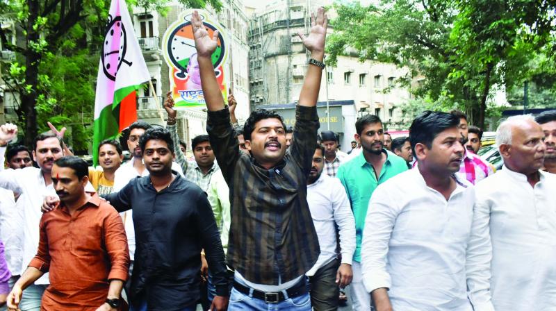 NCP supporters stage a protest in Mumbai on Wednesday against the registration of a money laundering case against party chief Sharad Pawar and others in connection with the MSCB Bank scam. (Photo: PTI) NCP supporters stage a protest in Mumbai on Wednesday against the registration of a money laundering case against party chief Sharad Pawar and others in connection with the MSCB Bank scam. (Photo: PTI)