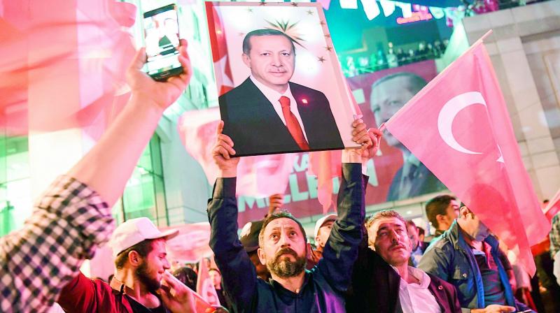A supporter of the “yes” camp brandishes a picture of Turkish president Recep Tayyip Erdogan during a rally in Istanbul after the results. (Photo: AFP) A supporter of the “yes” camp brandishes a picture of Turkish president Recep Tayyip Erdogan during a rally in Istanbul after the results. (Photo: AFP)