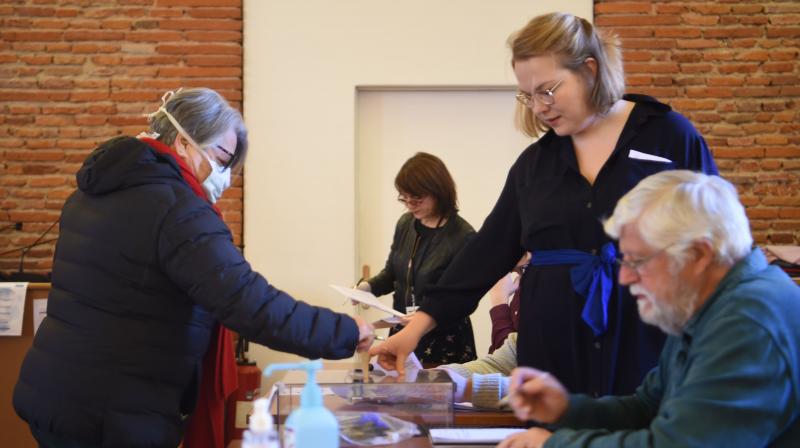A voter wearing a protective mask casts her ballot at a polling station in the center of Toulouse, southern France. AFP Photo