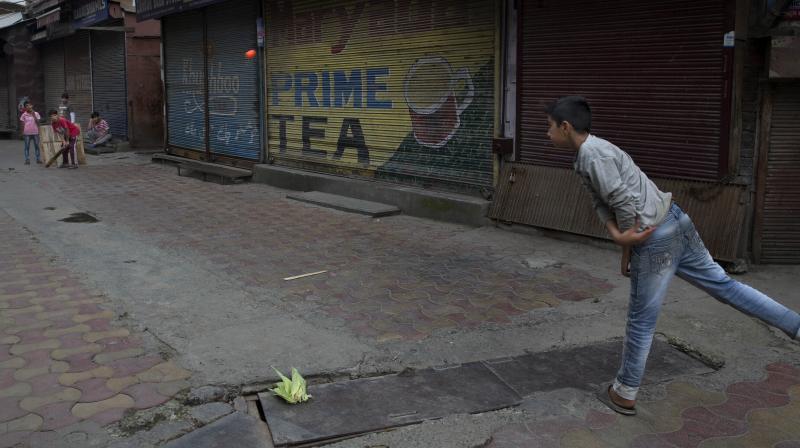 Children play cricket outside a closed market in central Srinagar on Tuesday. (Photo: AP) Children play cricket outside a closed market in central Srinagar on Tuesday. (Photo: AP)