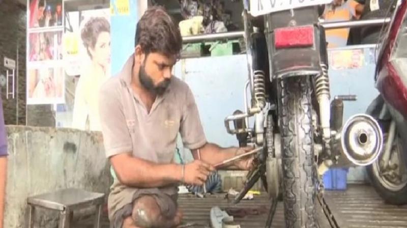 Prajapati who was afflicted with polio at a young age has not let disability hold him back and earns a living employed as an automobile mechanic in a shop. (Photo: ANI) Prajapati who was afflicted with polio at a young age has not let disability hold him back and earns a living employed as an automobile mechanic in a shop. (Photo: ANI)
