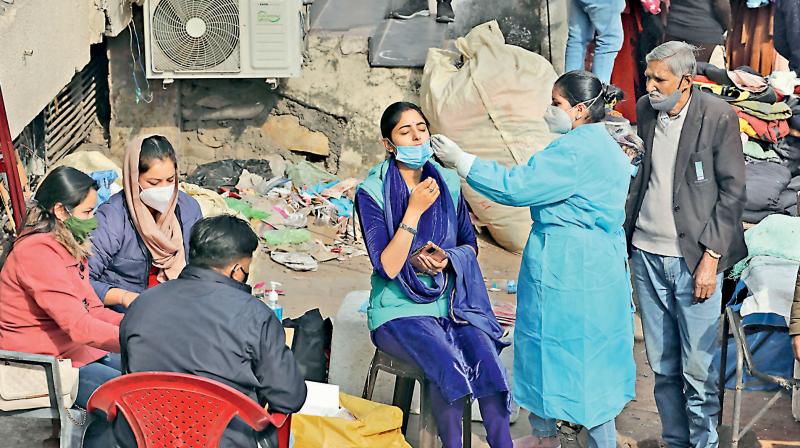 A health worker collects swab sample of a woman for Covid-19 test, in the wake of recent surge in Coronavirus cases. (DC file photo)