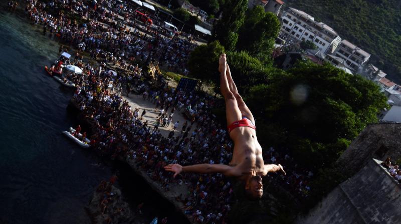 A Bosnian high diver takes off from the Stari Most or Old Bridge which straddles the Neretva River in Mostar during 452th traditional diving competition, on July 29, 2018. (AFP) A Bosnian high diver takes off from the Stari Most or Old Bridge which straddles the Neretva River in Mostar during 452th traditional diving competition, on July 29, 2018. (AFP)