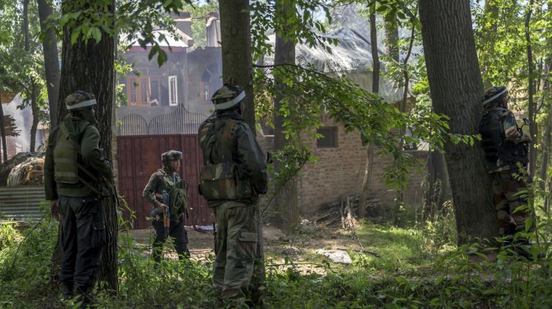 Indian army soldiers take position near the house where two suspected militants were killed in a gunbattle at Saimoh village, in Tral. (Photo: PTI) Indian army soldiers take position near the house where two suspected militants were killed in a gunbattle at Saimoh village, in Tral. (Photo: PTI)
