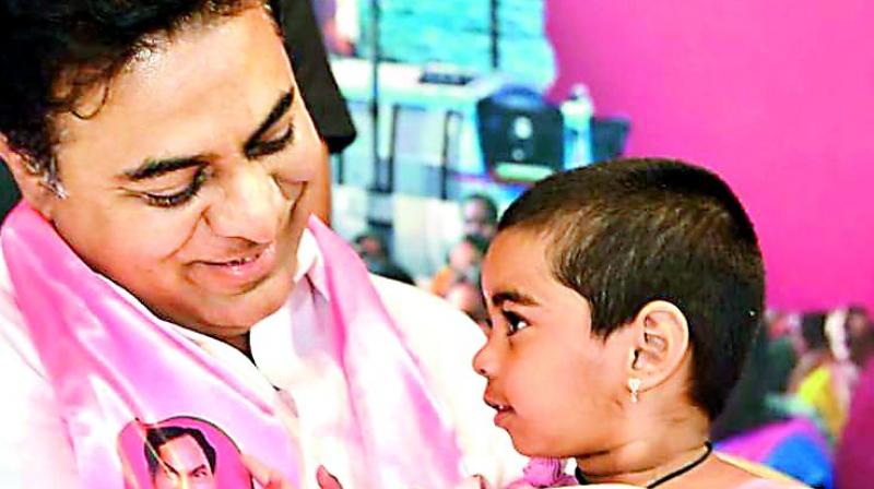 Caretaker minister K.T. Rama Rao holds the grand child of Karimnagar corporator Prabhavathi during a function at TRS Bhavan in Hyderabad on Friday. (Photo: Gandhi) Caretaker minister K.T. Rama Rao holds the grand child of Karimnagar corporator Prabhavathi during a function at TRS Bhavan in Hyderabad on Friday. (Photo: Gandhi)