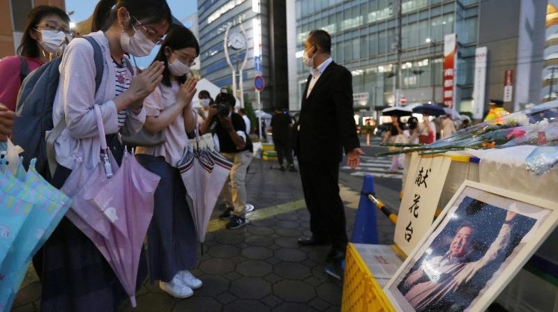 A photo of former Prime Minister Shinzo Abe is displayed on a makeshift memorial near the scene where Abe was fatally shot while delivering his speech to support a Liberal Democratic Partys candidate on Friday, in Nara, Saturday, July 9, 2022. (Photo: AP)