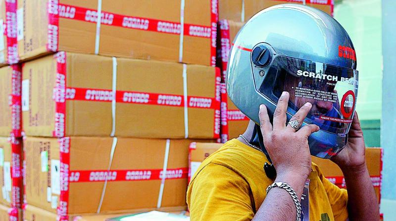 A youngster checks his helmet after purchasing it from a showroom in Vijayawada on Thursday. (Photo : DC) A youngster checks his helmet after purchasing it from a showroom in Vijayawada on Thursday. (Photo : DC)