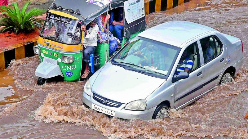 Motorists struggle to passs through the flooded road on Eluru road due to heavy rains on Friday morning (Photo: DC) Motorists struggle to passs through the flooded road on Eluru road due to heavy rains on Friday morning (Photo: DC)