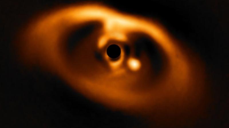 The photo provided by the European Southern Observatory ESO taken from the SPHERE instrument on ESO’s Very Large Telescope is the first clear image of a planet caught in the very act of formation around the dwarf star PDS 70. The planet stands clearly out, visible as a bright point to the right of the centre of the image, which is blacked out by the coronagraph mask used to block the blinding light of the central star. (ESO via AP) The photo provided by the European Southern Observatory ESO taken from the SPHERE instrument on ESO’s Very Large Telescope is the first clear image of a planet caught in the very act of formation around the dwarf star PDS 70. The planet stands clearly out, visible as a bright point to the right of the centre of the image, which is blacked out by the coronagraph mask used to block the blinding light of the central star. (ESO via AP)