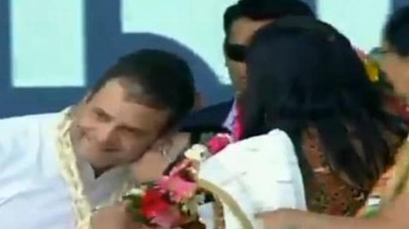 Rahul Gandhi blushed after the woman drags down his head and kisses him. (Photo: ANI | Twitter) Rahul Gandhi blushed after the woman drags down his head and kisses him. (Photo: ANI | Twitter)