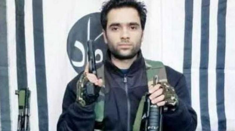 In the video, Adil Ahmad is armed with rifles and standing in front of what appear to be Jaish-e-Mohammad banners. (Photo: YouTube screengrab) In the video, Adil Ahmad is armed with rifles and standing in front of what appear to be Jaish-e-Mohammad banners. (Photo: YouTube screengrab)