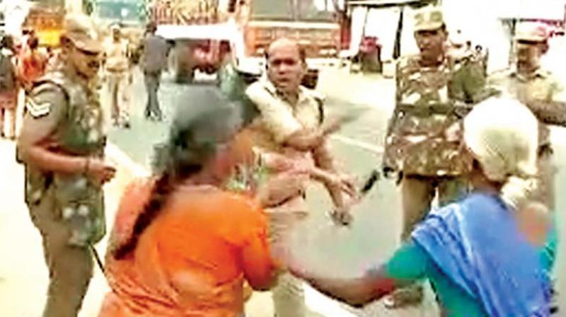 A video grab shows DSP Pandiarajan assaulting a woman protester in Tirupur on Tuesday. A video grab shows DSP Pandiarajan assaulting a woman protester in Tirupur on Tuesday.