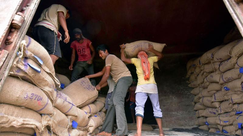 Workers transfer essential items from a goods train to trucks for transportation to various parts of the state during the nationwide lockdown to curb the spread of coronavirus, in Nagaon. PTI photo