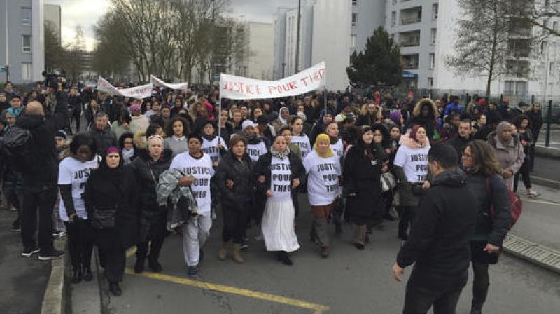 People march in the streets of Aulnay-sous-Bois, north of Paris, France, holding a sign reading People march in the streets of Aulnay-sous-Bois, north of Paris, France, holding a sign reading
