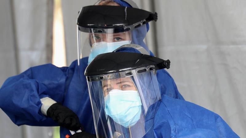 Volunteers Eva Grout (TOP), and Jennifer Niebergall work while conducting drive-through coronavirus testing at Malibu City Hall in Malibu California. PTI photo