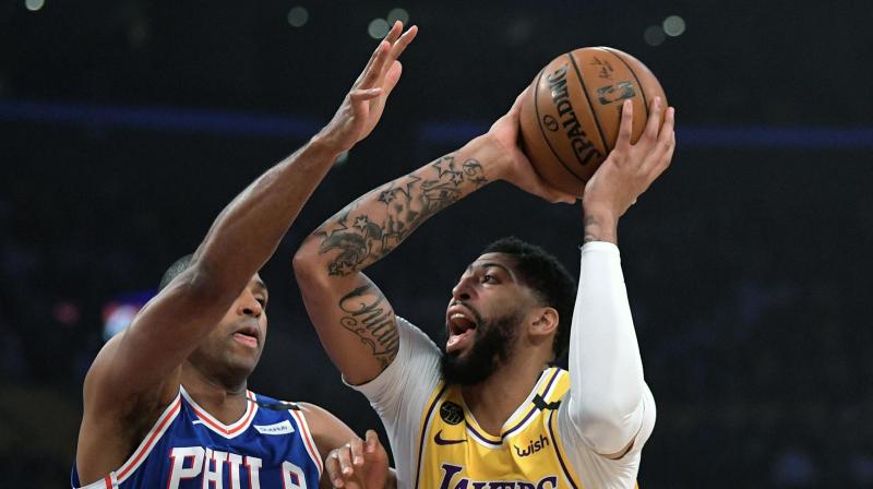 Los Angeles Lakers forward Anthony Davis, right, shoots as Philadelphia 76ers forward Al Horford defends during the first half of an NBA basketball game Tuesday, March 3, 2020, in Los Angeles. (AP