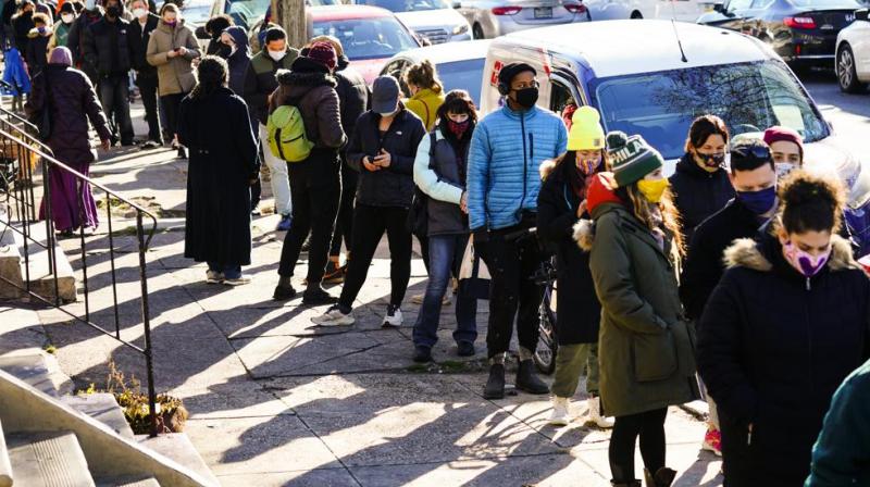 City residents wait in a line extending around the block to receive free at-home rapid COVID-19 test kits in Philadelphia, Monday, Dec. 20, 2021. (AP/Matt Rourke)