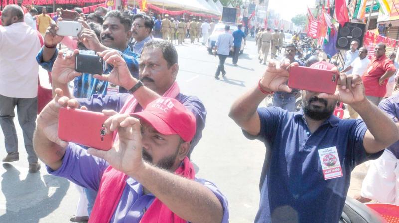 CITU activists capture images of the rally being taken out along the MG Road in front of the Secretariat on Tuesday, expressing solidarity with the two-day all-India general strike. In the background is the huge shamiana covering half the road up to the divider, erected by the organizers in flagrant violation of the court order against blocking roads. Union leaders took turns, addressing the public meeting of strikers seated under the shamiana. Chief Minister Pinarayi Vijayan and ministers kept off the Secretariat. (Photo: A.V. Muzafar) CITU activists capture images of the rally being taken out along the MG Road in front of the Secretariat on Tuesday, expressing solidarity with the two-day all-India general strike. In the background is the huge shamiana covering half the road up to the divider, erected by the organizers in flagrant violation of the court order against blocking roads. Union leaders took turns, addressing the public meeting of strikers seated under the shamiana. Chief Minister Pinarayi Vijayan and ministers kept off the Secretariat. (Photo: A.V. Muzafar)
