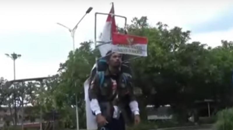 He walks backwards with the help of a headpiece built with plastic pipes, fixed with a rear-view mirror which allows him to walk backwards. (Photo: Screengrab/Metro TV) He walks backwards with the help of a headpiece built with plastic pipes, fixed with a rear-view mirror which allows him to walk backwards. (Photo: Screengrab/Metro TV)