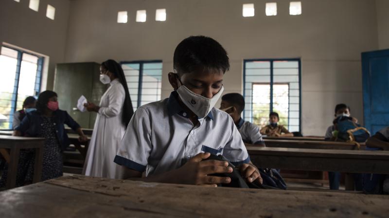 Students wearing masks sit inside a classroom as schools reopened in Kochi, Kerala. (Photo: AP)