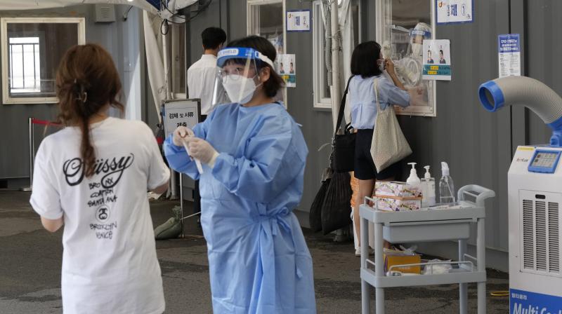 Medical workers takes nasal samples from residents for coronavirus tests at a makeshift testing site in Seoul, South Korea, Tuesday, July 20, 2021. (AP/Ahn Young-joon)