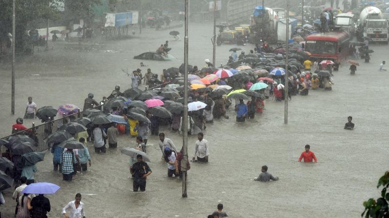 Heavy rains Tuesday brought Mumbai to a halt flooding vast areas of the city. People were stranded for hours as train services were halted and water levels kept creeping up. (Photo: AP/PTI) Heavy rains Tuesday brought Mumbai to a halt flooding vast areas of the city. People were stranded for hours as train services were halted and water levels kept creeping up. (Photo: AP/PTI)